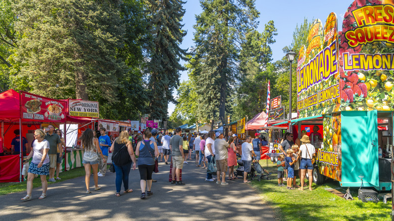 Visitors walking past food tents at the annual Street Fair on a clear summer day in Coeur d'Alene, Idaho