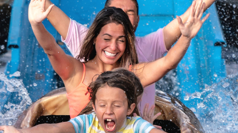 A family getting soaking wet on a water roller coaster