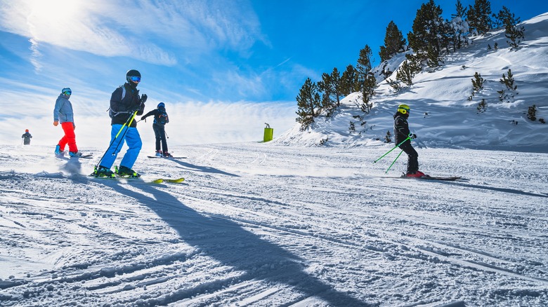Group of people downhill skiing in the Pyrenees, Andorra, in bright jackets on white snow