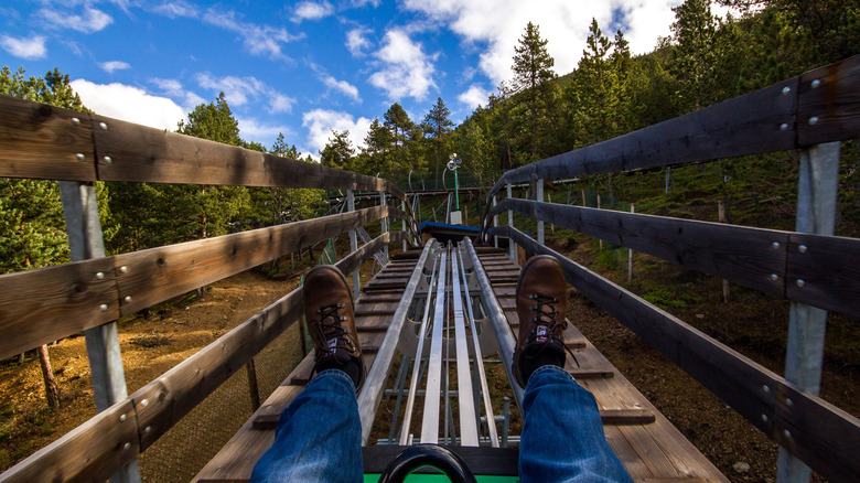 Boots stretched out on the tree-surrounded, wooden Alpine slide, Tobotronc, in Andorra