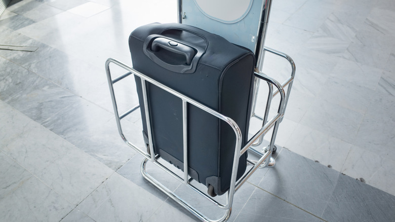 Using a measuring frame in airport departures to check the size of aircraft carry-on baggage before boarding a flight.
