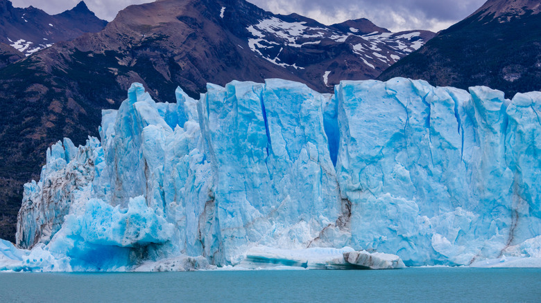 View of the blue ice at the Perito Moreno Glacier in Patagonia, Argentina with mountains in the background