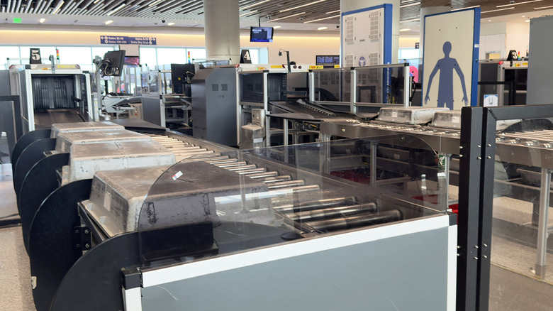A modern airport security checkpoint with automated belts and backscatter machines