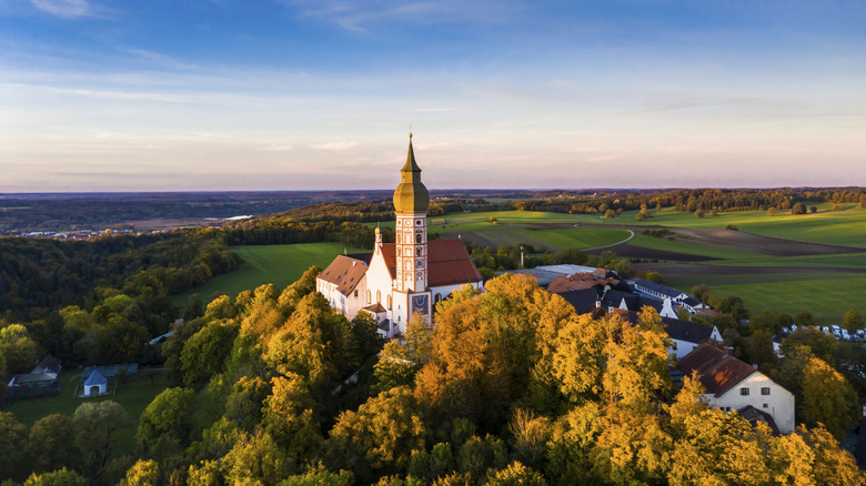 Ornate tower abbey standing tall over the meadows and forests of Bavaria, Germany
