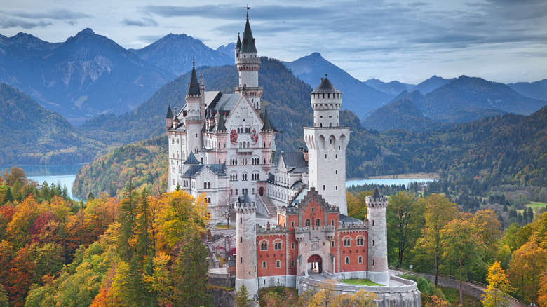 White towers of Neuschwanstein Castle set against the Bavarian Alps during the autumn