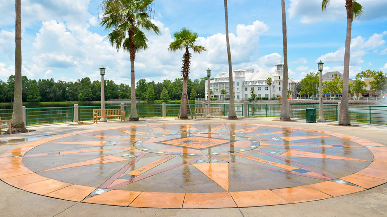 Decorative compass rose plaza with palm trees and waterfront view in Celebration, Florida, featuring the town seal.