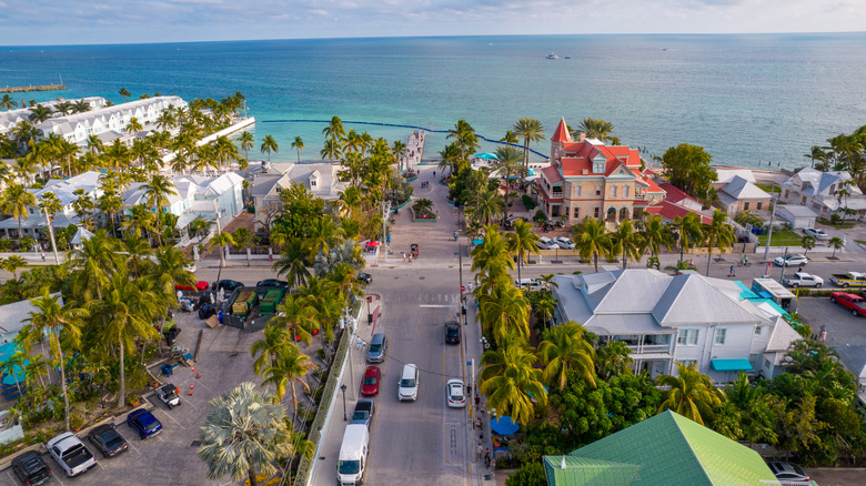 Beautiful aerial view of Key West, with bright blue water, palm tres, and colorful buildings visible