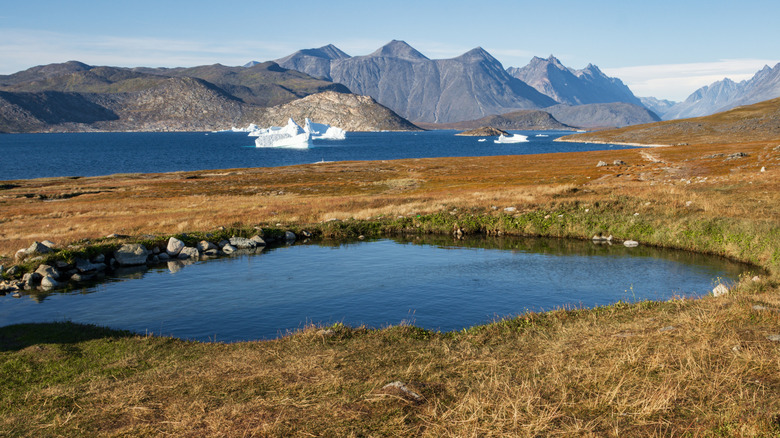 Hot pool overlooking mountains and ocean on Uunartoq Island in Greenland