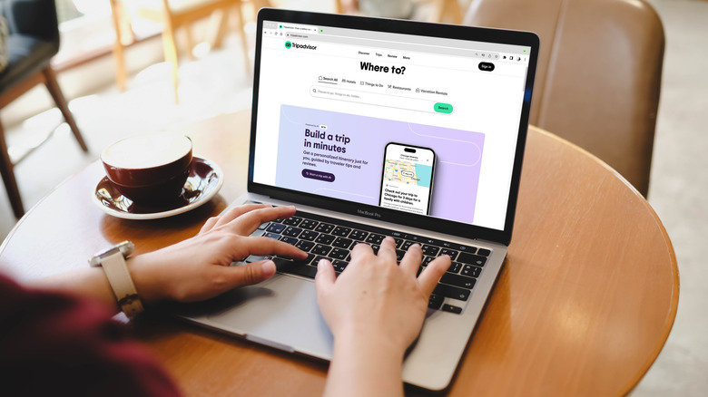 A woman uses a laptop with Tripadvisor on the screen