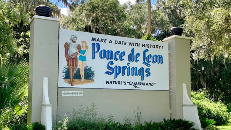 Vintage-style sign for De Leon Springs State Park, surrounded by trees