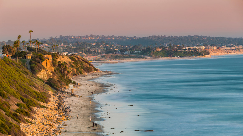 Hikers walking along the Pacific Ocean at San Elijo State Beach, Encinitas CA