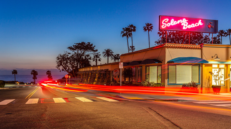 The streets at night in Solana Beach, with a neon "Solana Beach" sign atop a one-story building