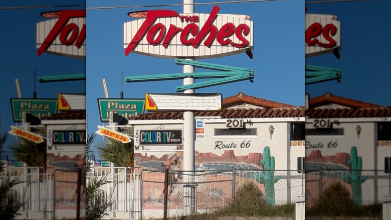 Retro motel signs and a building with a Route 66 desert mural in Barstow, California