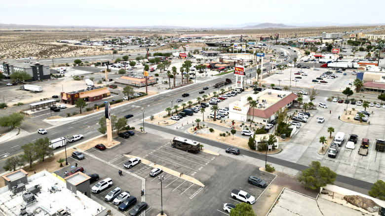 Aerial view of Barstow, California, with parking lots, a street, and chain shops and restaurants