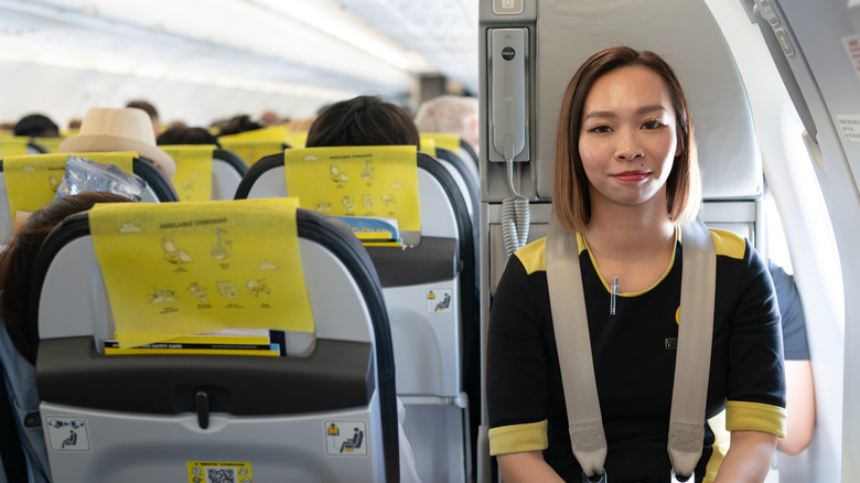 A Scoot flight attendant seated in the Airbus A321neo cabin during takeoff and climb.