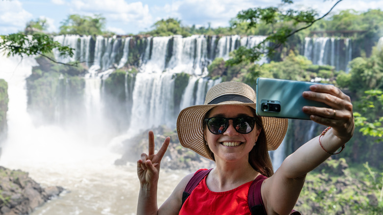 A woman takes a selfie at the Cataratas do Iguaçú