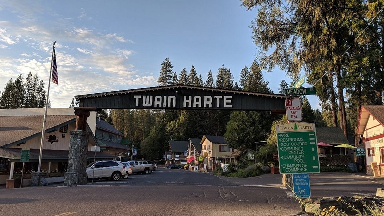 Stone and wooden car archway over a small road with a sign that says "Twain Harte"