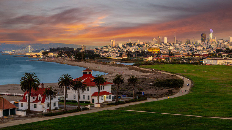 aerial view of the Presidio at dusk with grassy areas, walking trails, plam trees, and the bay