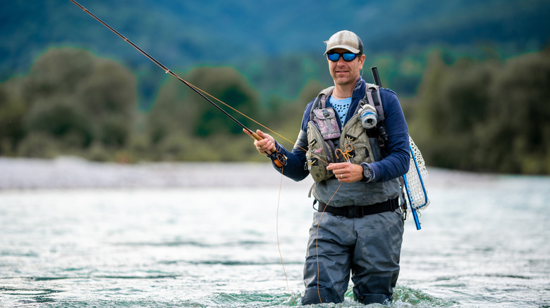 A man fly fishes in a lake