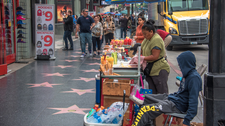 Street vendors on a sidewalk with stars and souvenir ads