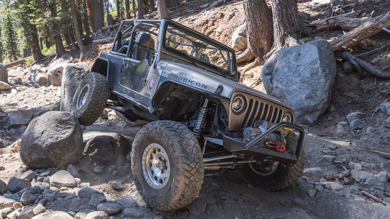 A Jeep Wrangler straddles boulders along Rubicon Trail, California