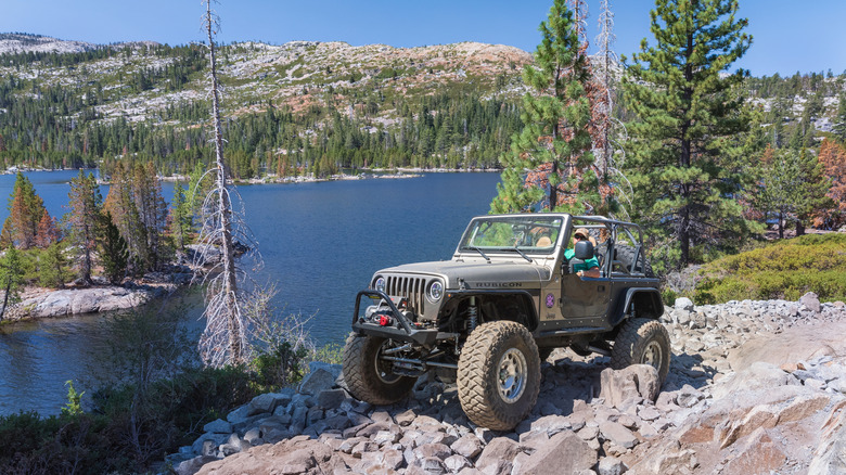 A Jeep Wrangler parked alongside a remote lake in the Sierra Nevada Mountains