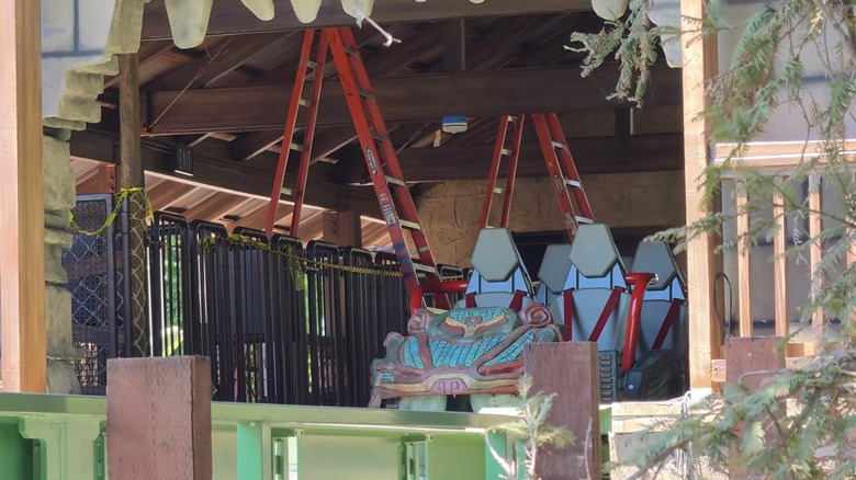 A Montezooma: The Forbidden Fortress roller coaster car sitting on a track next to ladders