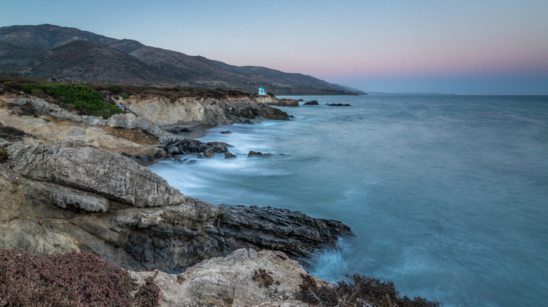 Rocky cliffs above the ocean, photographed at twilight, in Leo Carrillo State Beach, Malibu, California.