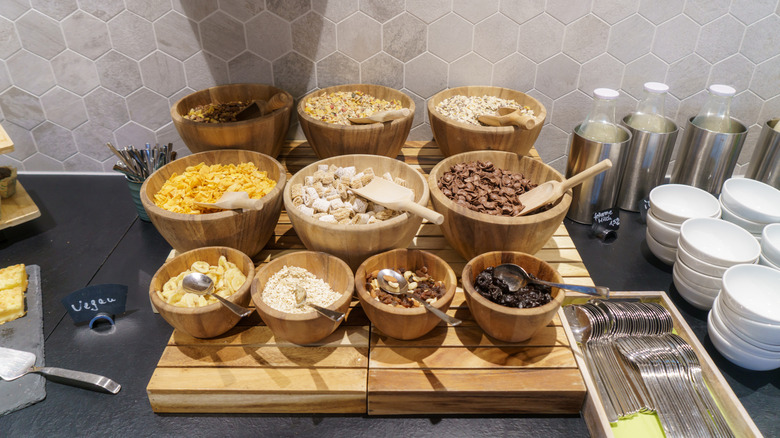 Hotel breakfast bar with bowls of cereals and toppings