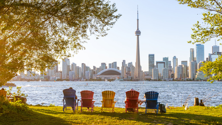Adirondack chairs on Toronto Island Park at sunset with Toronto City skyline in the background