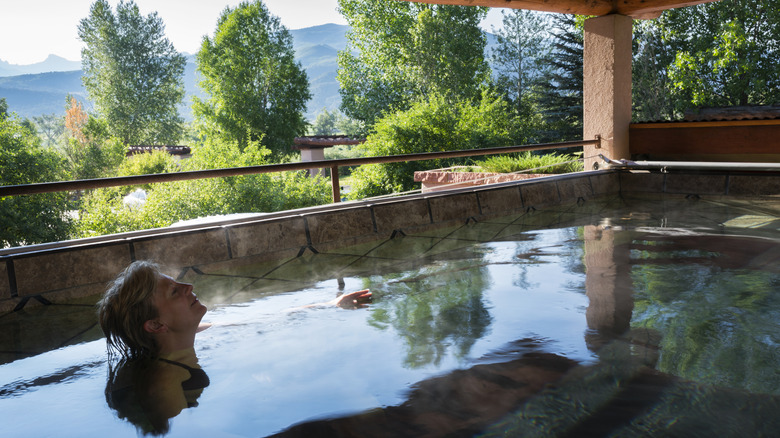A woman relaxes in a hot thermal pool at Chipeta Solar Springs Resort, Ridgway, Colorado