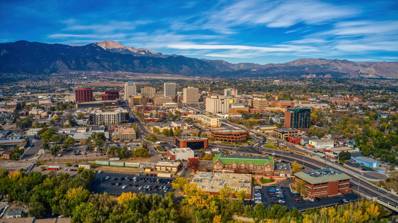 Aerial view of downtown Colorado Springs with mountains in background on clear day