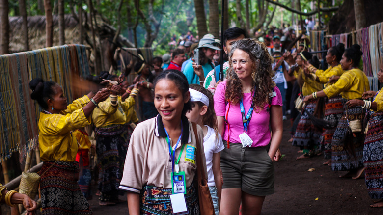 Passengers on a National Geographic cruise participate in cultural experience at port of call.