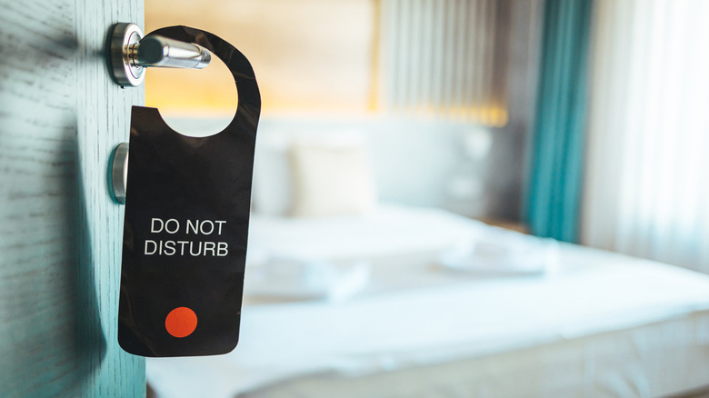 "Do Not Disturb" sign on hotel door handle