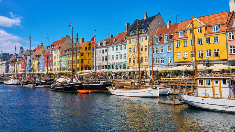 The busy streets of Nyhavn, Copenhagen, near the boat-lined canal on a sunny day