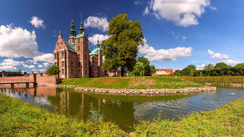 Rosenborg Castle and moat surrounded by greenery on a sunny day, Copenhagen