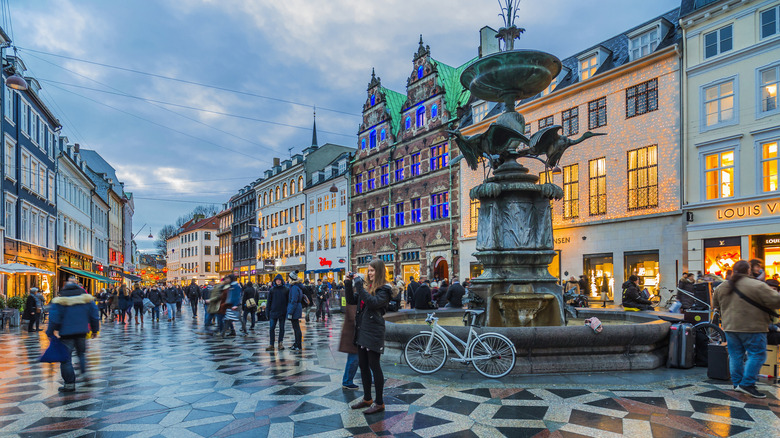 Bustling pedestrian street of Strøget in Copenhagen, Denmark, lit up at dusk