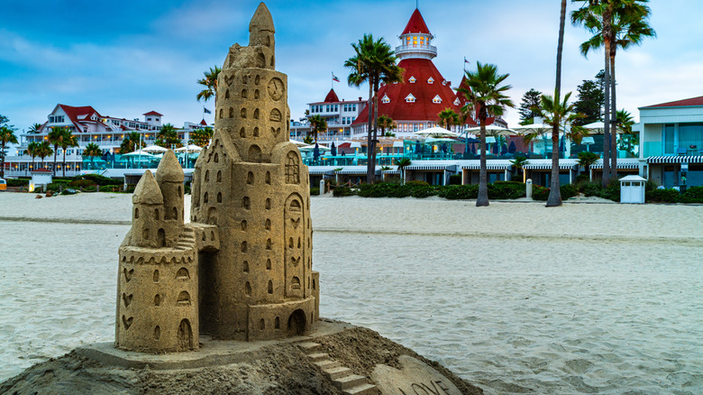 a sand castle sculpture with the iconic hotel del coronado turret in the background