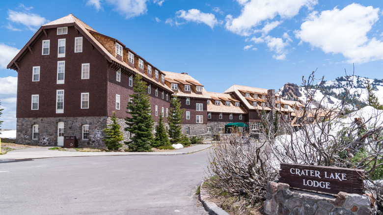 View of the entry road to Crater Lake Lodge with snowy mountains in the back
