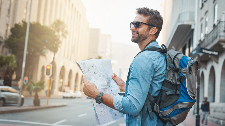Young traveler looking at a map while touring a foreign city.