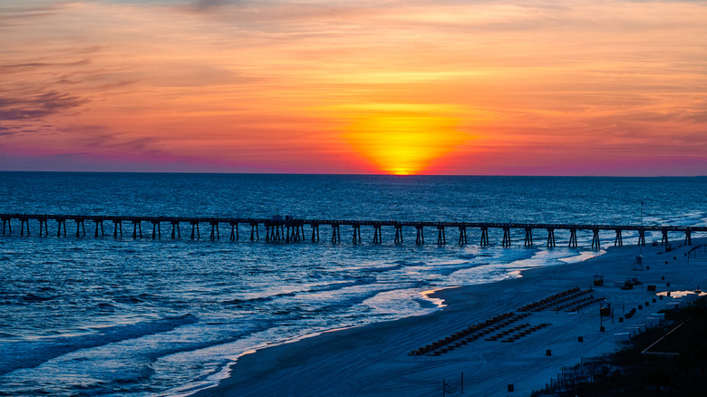 Blue hour at Panama City Beach, Florida, with the sun setting behind a pier