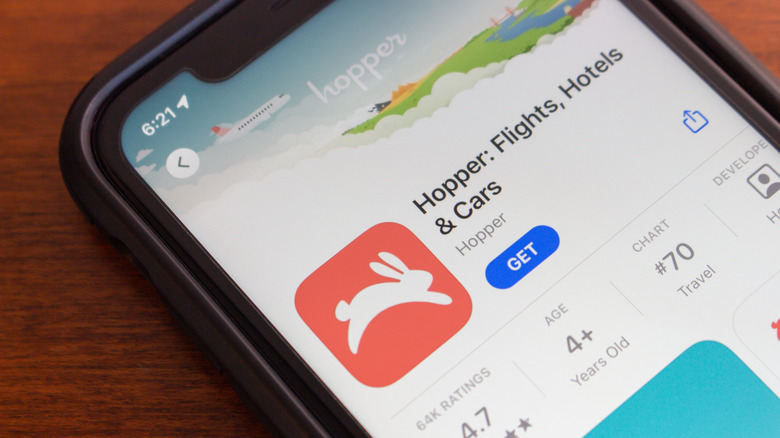Close-up of a cell phone displaying the download page for the Hopper travel app.
