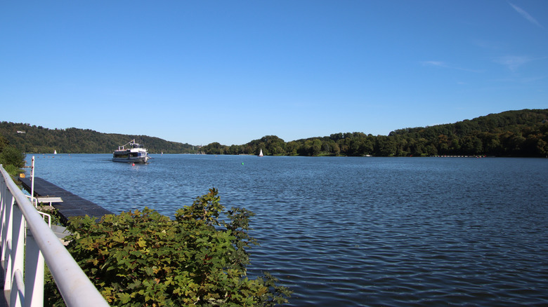 Sunny view of Lake Baldeney with a sailboat and a tour boat on the water