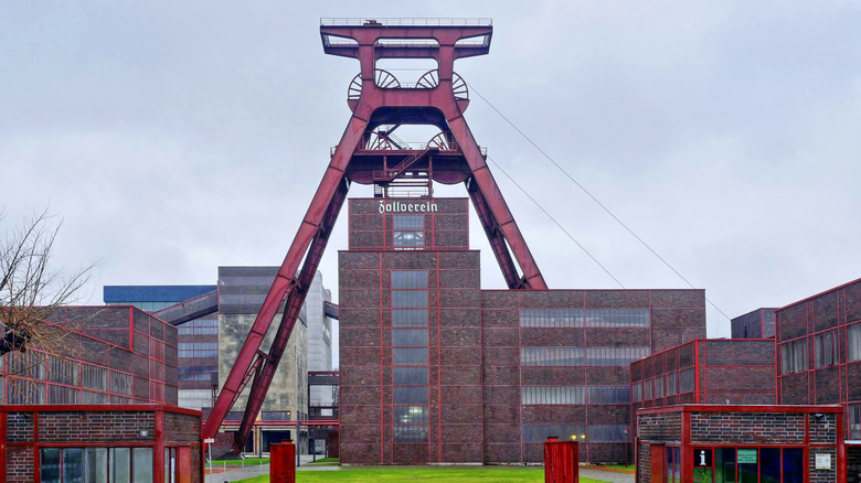 Exterior view of Zollverein Coal Mine Industrial Complex on a cloudy day, with the famous Shaft XII visible