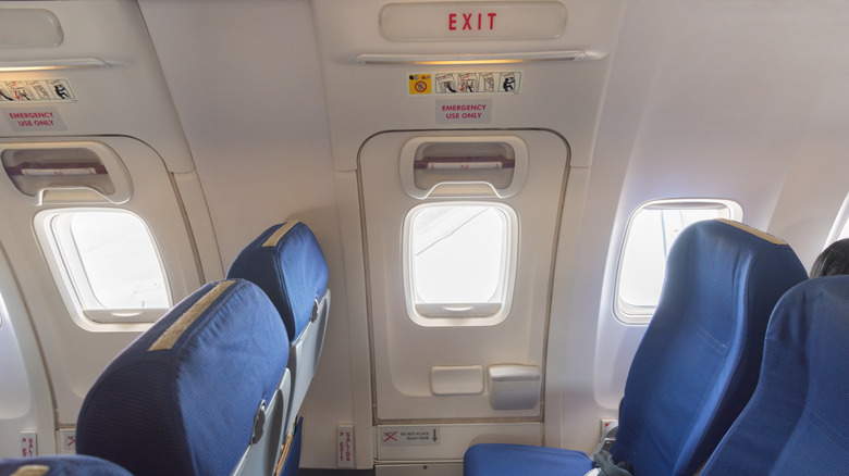 Two empty exit rows are pictured on an airplane.