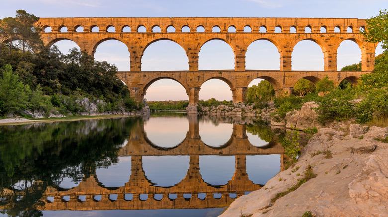 Pont du Gard reflected in the Gardon River at sunrise
