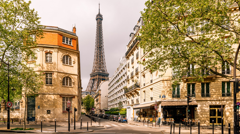 Eiffel Tower photographed down a Parisian street.