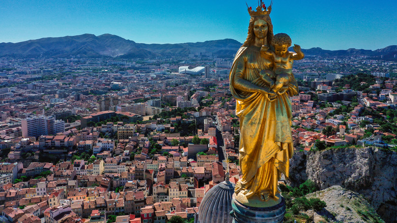 view from the top of the basilica with golden statue of mary overlooking Marseille and mountains in background