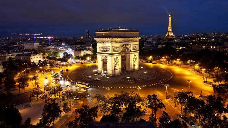 arc of triumph and eiffel tower monuments illuminated at night