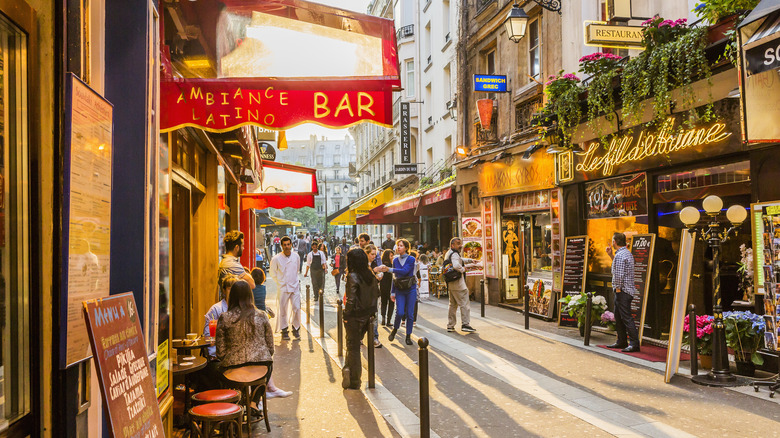 bustling pedestrian street in paris lined with bars, cafes and restaurants